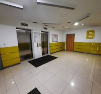 Interior with two elevators, yellow walls, and light tiles in a 2-room apartment.