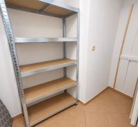 Storage space in a 2-room apartment with a metal shelf and tiles.