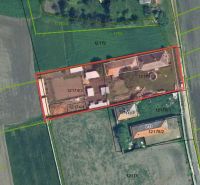 Aerial view of family houses in Komárno surrounded by fields and vegetation.