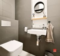 Compact bathroom in a 2-room apartment with a sink, mirror, and toilet.