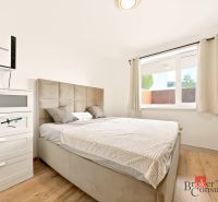 Bedroom in a 2-room apartment with a bed and a wardrobe, floor with wooden decor.