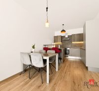 A kitchen in a 2-room apartment with a dining table and a floor with a wooden decor.