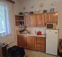 Kitchen with wooden cabinets, microwave, and refrigerator, Land - housing.