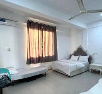 A room with a bed, a table, and a sofa in a 2-room apartment.
