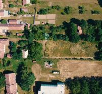 Aerial view of plots - housing in Čermany, surrounded by greenery and road infrastructure.