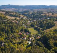 Aerial view of Recreational plots in Štiavnické Bane surrounded by green forests and hills.