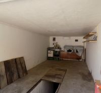 Garage with shelves, road floor, racks, and stored items.