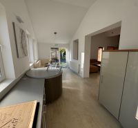 A space in a family house with a bright kitchen and dining area, and a wooden decor floor.