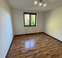 A room in a family house with a wooden decor floor and simple lighting.