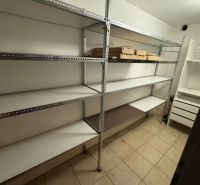 Storage space in a family house with metal shelves and tiled flooring.