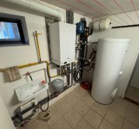 Technical room with a radiator, sink, and boiler in a family house.