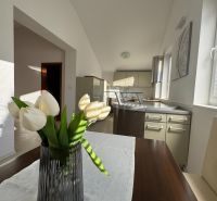 A kitchen in a family house with a decorative vase and white flowers on the table.