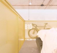 Attic space in a 2-room apartment with a bicycle and a sofa by the railing.
