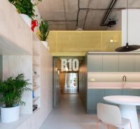 Interior of a 2-room apartment with plants, concrete ceiling, and built-in wardrobes.