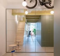 A mirrored wall and stairs leading to the floor in a 2-room apartment.