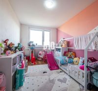 Children's room in a 3-room apartment with toys and a bed, floor with wooden decor.