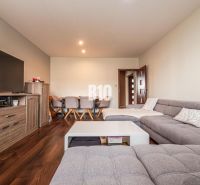 A comfortable living room with a gray sofa and a wooden decor floor in a 3-room apartment.