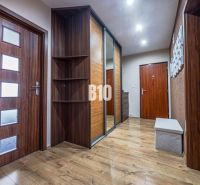 A hallway in a 3-room apartment with a wooden decor floor and a built-in wardrobe.