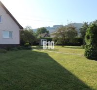 A family house in Žilina with a well-maintained garden and a view of the surrounding hills.