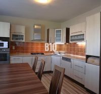 A kitchen in a family house with wooden decor and appliances, featuring a spacious dining table.