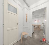 A bright hallway in a 2-room apartment with wooden furniture and a chair.