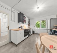 A kitchen in a 2-room apartment with a wooden decor floor and a spacious table.