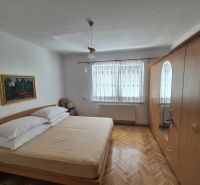 A bedroom in a family house with a wooden decor floor, wardrobes, and a painting.