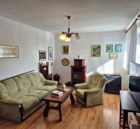 Living room in a family house with a sofa and an armchair, floor with wooden decor.