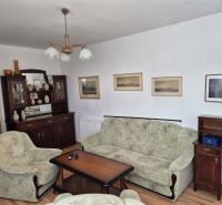 Living room of a family house with armchairs, a sofa, and a furniture set.