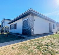 A family house in Horné Saliby with stone details and a landscaped garden.