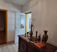 Entrance hall in a family house with decorative furniture and wood-patterned flooring.