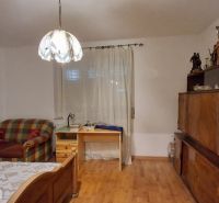 A room in a family house with a single bed and a wooden decor floor.