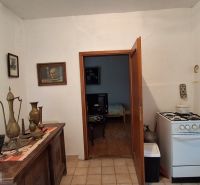 A kitchen with a gas stove in a family house, decorative vases on a sideboard.