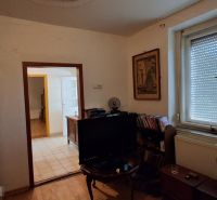 Room with a television, radiator, and tiled stove in a family house.