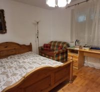 Bedroom in a family house with wooden decor, a bed, and a desk.