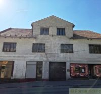Commercial premises in Modrý Kameň with a worn facade and a sloped roof.