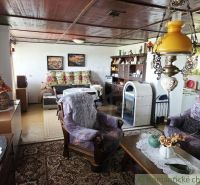 The interior of the cottage with decorative lamps, a sofa, rugs, and decorative furniture.