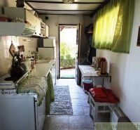 A kitchen in a cottage with traditional equipment, a cozy atmosphere, and a view of the garden.