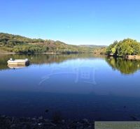 A picturesque view of a lake surrounded by greenery in the Gardens near Krupina.