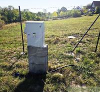 An electrical cabinet in the Gardens in Krupina on a green meadow.