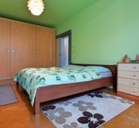 Green bedroom in a 2-room apartment with a double bed, wardrobe, and carpet.