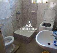Bathroom in a family house with a shower, toilet, and washing machine.