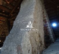 The attic of a family house with a wooden structure and an old brick wall.
