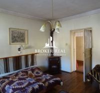 A room in a family house with a wooden decor floor and simple furnishings.