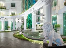 Apartment construction with impressive columns and a lion at the entrance.
