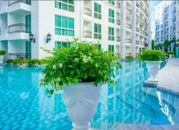 Exterior in Pattaya, apartment construction by the pool with floral decoration.