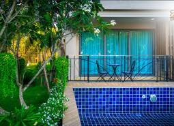A garden with a swimming pool and seating area under construction in an apartment complex in Pattaya.