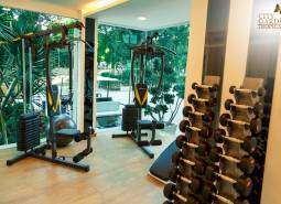 A gym under construction in an apartment building with views of the park through glass walls.