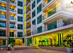 Apartment construction in Pattaya: a modern building with glass balconies and night lighting.