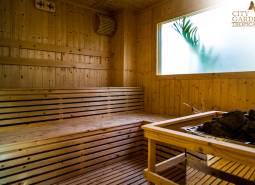 Wooden sauna with a glass window and the real estate agency's logo.